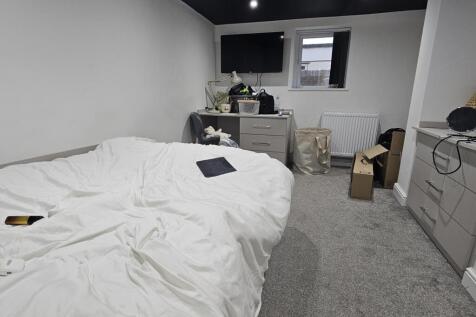 A well-maintained bedroom featuring a large dou...