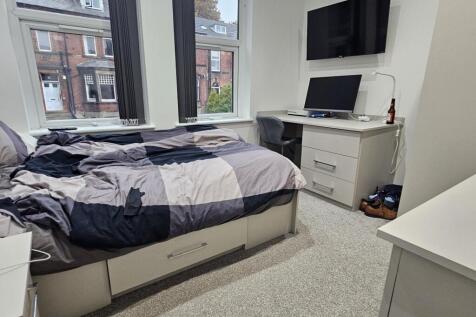 A well-lit, tidy bedroom featuring a double bed...
