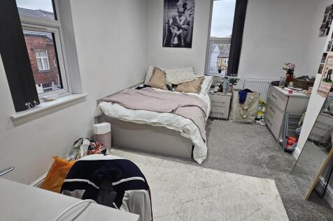 A cozy bedroom with a double bed positioned nea...