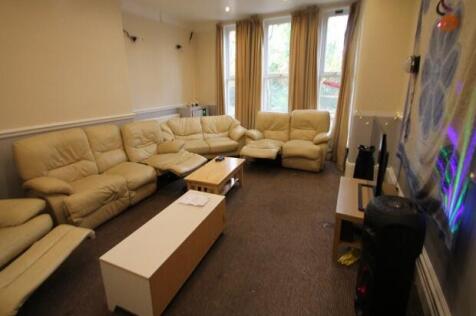 A spacious, well-lit living room featuring comf...