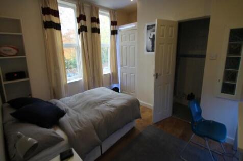 A cozy bedroom featuring a single bed near a wi...