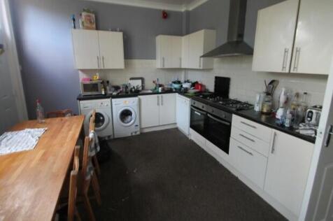 A functional kitchen with white cabinetry and a...