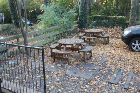 An outdoor garden area with several picnic tabl...