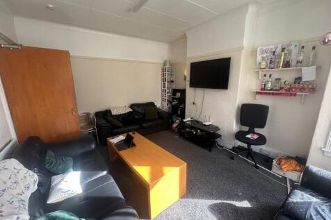 A spacious and well-lit living room featuring m...