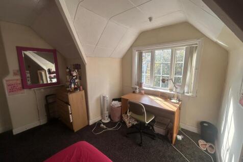 A well-lit bedroom with a large window providin...