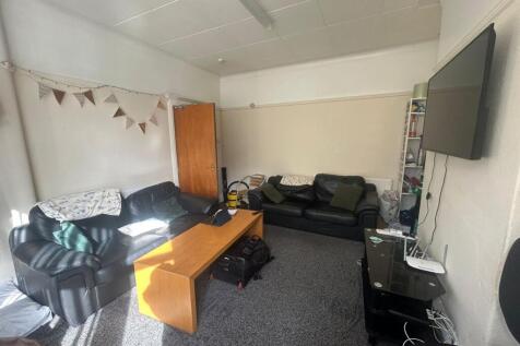 A cozy, well-lit living room featuring comforta...