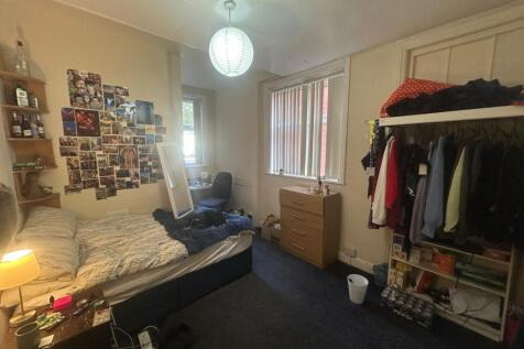 A cozy bedroom with a bed, some personal touche...