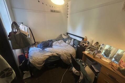 A cozy bedroom with a large bed, bedside tables...