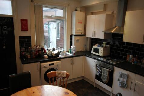 Bright kitchen with modern white cabinets, blac...