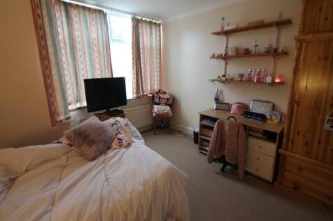 A cozy bedroom featuring a neatly made bed, a s...