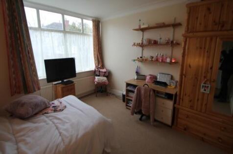 A cozy bedroom featuring a double bed, a wooden...