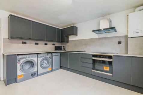 Modern fitted kitchen with dark grey cabinetry,...