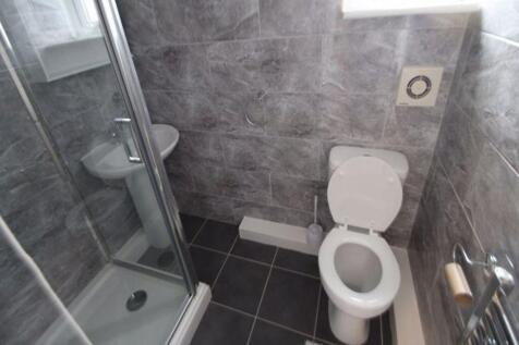 A modern bathroom featuring a glass-enclosed sh...