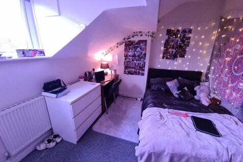 Cozy attic bedroom with a sloped ceiling and a ...