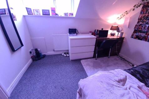 A neat and well-lit room corner with carpeted f...