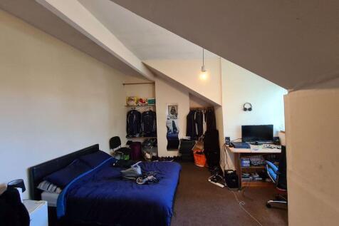 A spacious master bedroom featuring a comfortab...