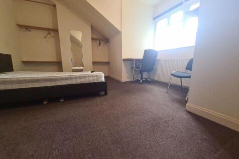 A simple single bedroom featuring a neatly made...