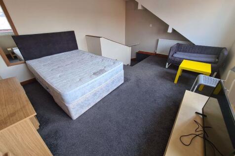 A spacious double bedroom featuring a large bed...
