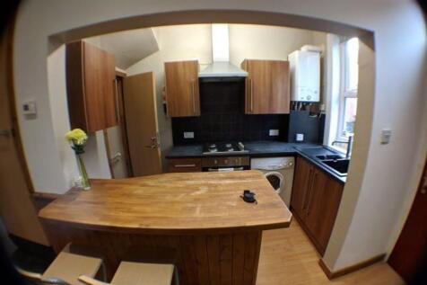 A modern kitchen featuring warm wooden cabinetr...