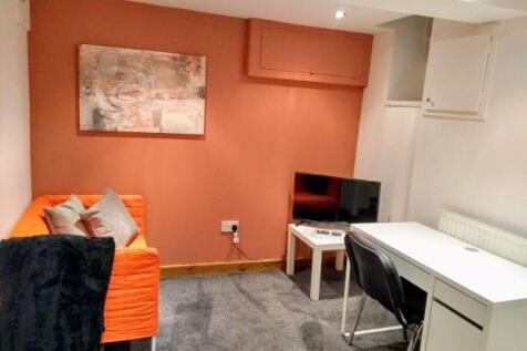 A cozy communal lounge featuring a bright orang...