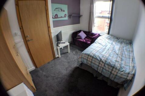 A cozy single bedroom featuring a comfortable b...