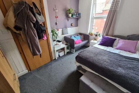 A cozy single bedroom featuring a comfortable b...