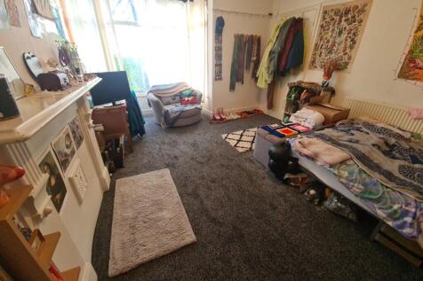 A cozy bedroom with a single bed next to a wind...