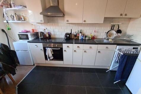 A modern kitchen featuring white cabinets, a bu...