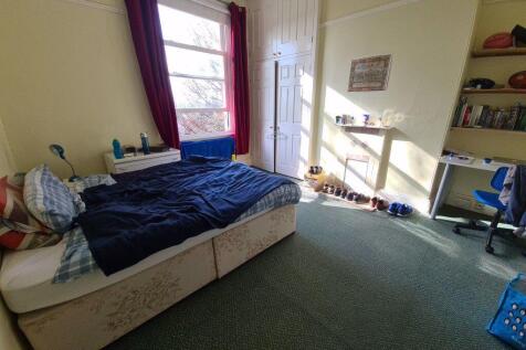 A cozy bedroom featuring a single bed, with a w...