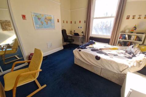 A cozy bedroom with a large window allowing ple...
