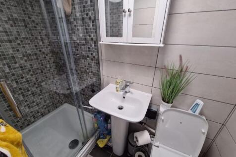 A tidy bathroom featuring a white sink, toilet,...