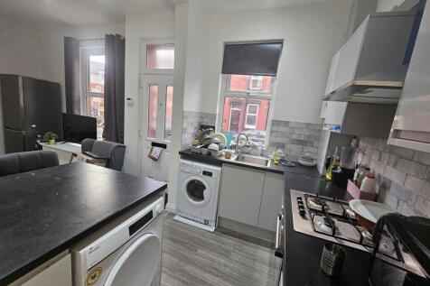 Modern kitchen featuring sleek countertops, a w...