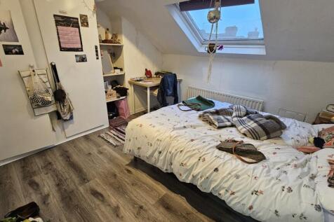 A cozy bedroom featuring a double bed with neat...