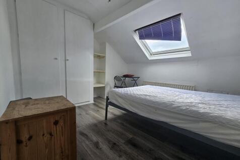 A well-lit, tidy single bedroom featuring a com...