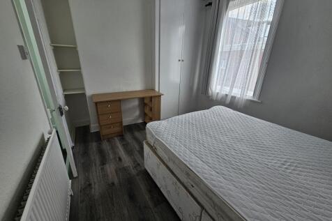 A well-lit, neatly maintained bedroom with a co...