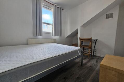 A bright and inviting bedroom featuring a comfo...