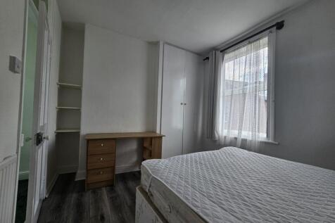 A bright and tidy bedroom featuring a comfortab...