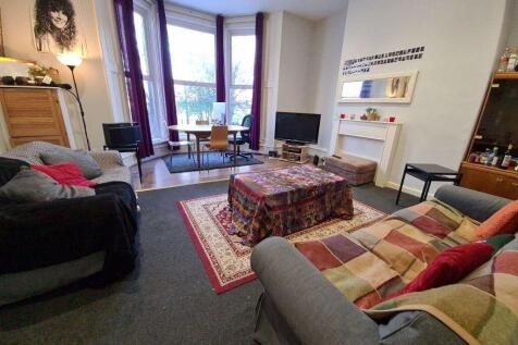 A spacious and well-lit living room featuring c...
