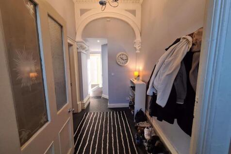 A well-lit, inviting hallway with a striped rug...