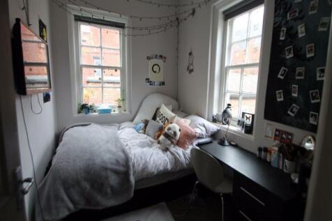 A cozy student bedroom featuring a single bed, ...