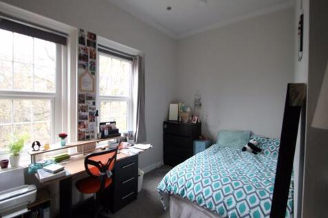A cozy student bedroom featuring a comfortable ...