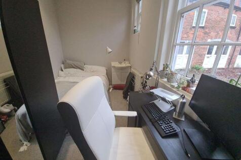 A well-lit study area featuring a comfortable c...