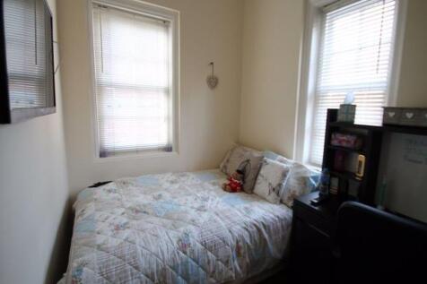 A cozy bedroom featuring two windows providing ...