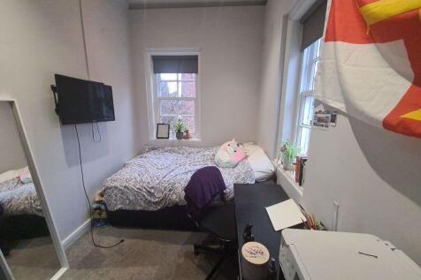 A cozy bedroom featuring a double bed with some...