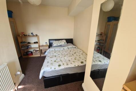 A well-lit double bedroom featuring a comfortab...