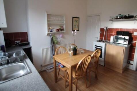 A bright and clean kitchen with a wooden dining...