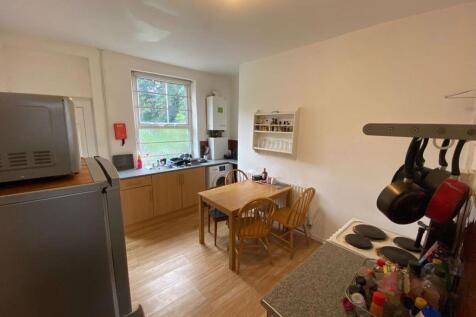 A well-lit and tidy kitchen area with modern ap...