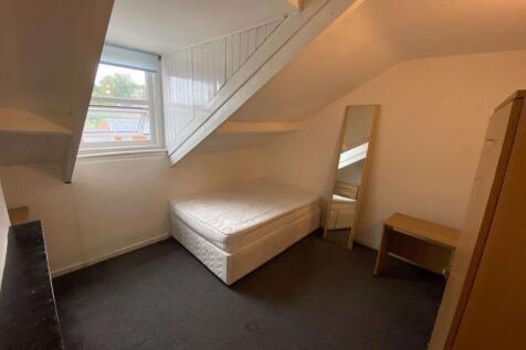 A cozy student bedroom featuring a single bed, ...