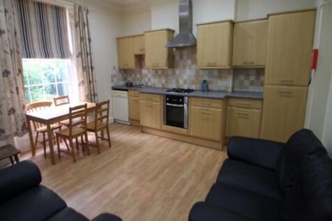 A bright and tidy kitchen featuring wooden cabi...