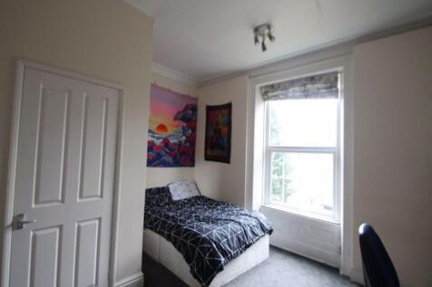 A cozy double bedroom featuring a large window ...
